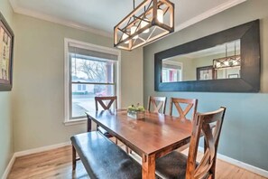 A dining area with a wooden table and benches, a large window, and a modern chandelier. - Walk to FIFA World Cup! 1mi to AT&T Stadium - Texas Live! - GlobeLife Field. (Arlington)