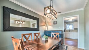 A dining area with a wooden table, chairs, a hanging light fixture, and a large mirror on the wall. - Walk to FIFA World Cup! 1mi to AT&T Stadium - Texas Live! - GlobeLife Field. (Arlington)