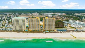 Un hôtel situé sur la côte, composé de plusieurs immeubles de grande hauteur, offrant un accès direct à la plage et une vue sur le paysage urbain environnant.