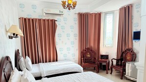 A hotel room with two beds, a desk, a chair, an air conditioner, and a television. - Hong Tam Hotel (Ho Chi Minh City)
