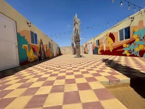 Explore vibrant corridors with colorful murals and string lights.