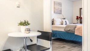 A compact room with a bed, a small table with a chair, and a potted plant. - N. Dallas Updated 1 Bedroom Apartment (Dallas)