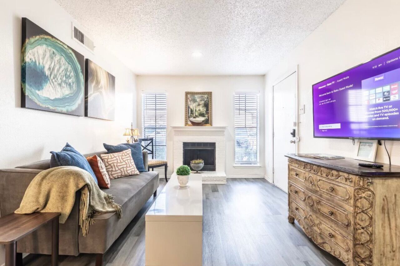 A living room with a fireplace, a sofa, a coffee table, and a television.