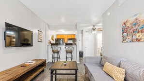 A modern living room with a sofa, a coffee table, and a TV mounted on the wall. - PERFECT FOR LONG STAYS! CENTRAL DFW (Dallas)