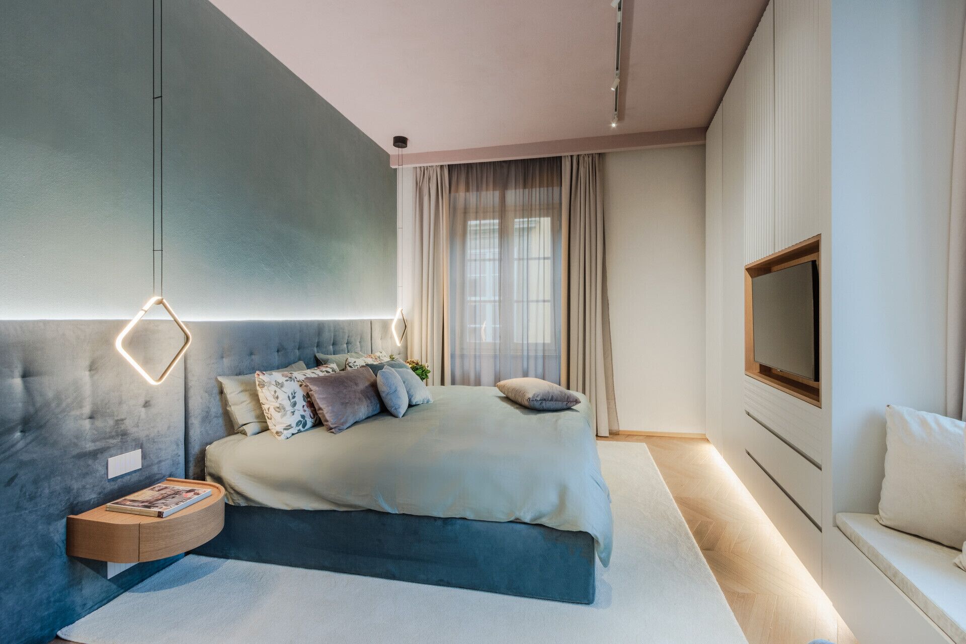 A modern bedroom with a bed, bedside table, and a TV.