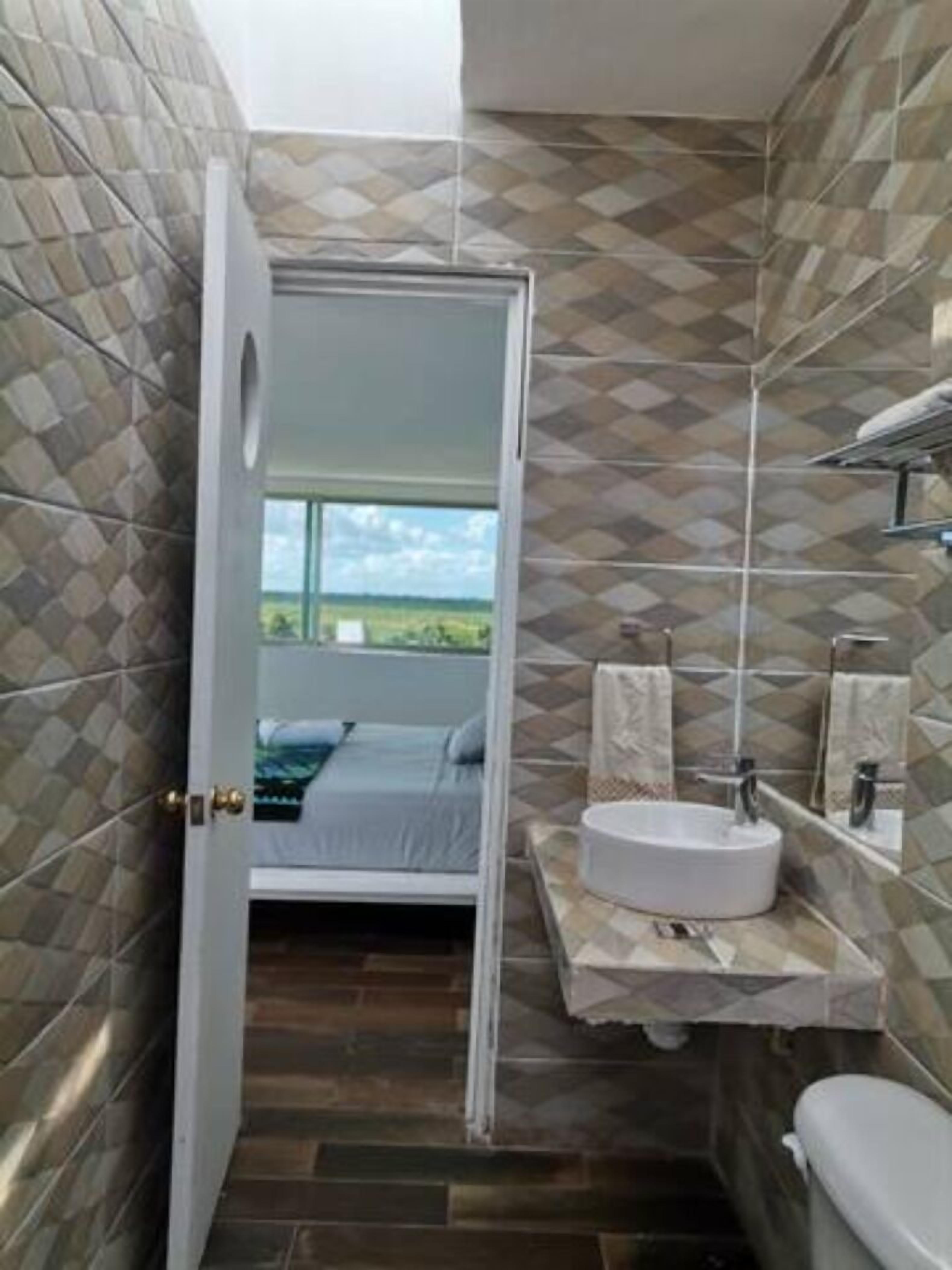 Un bagno con un letto, un lavandino e un water.