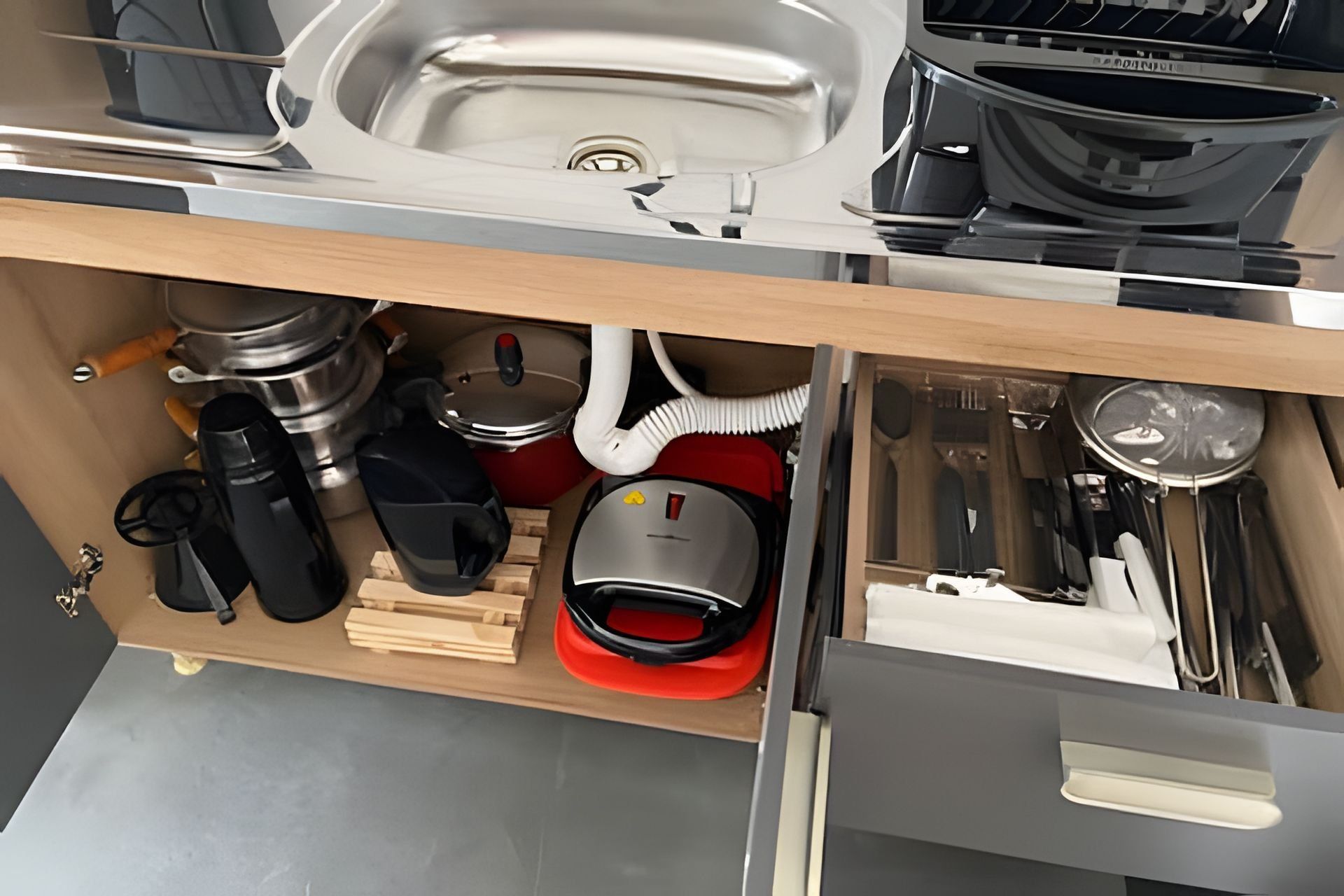 Una cocina con un lavamanos, estufa y diferentes utensilios.