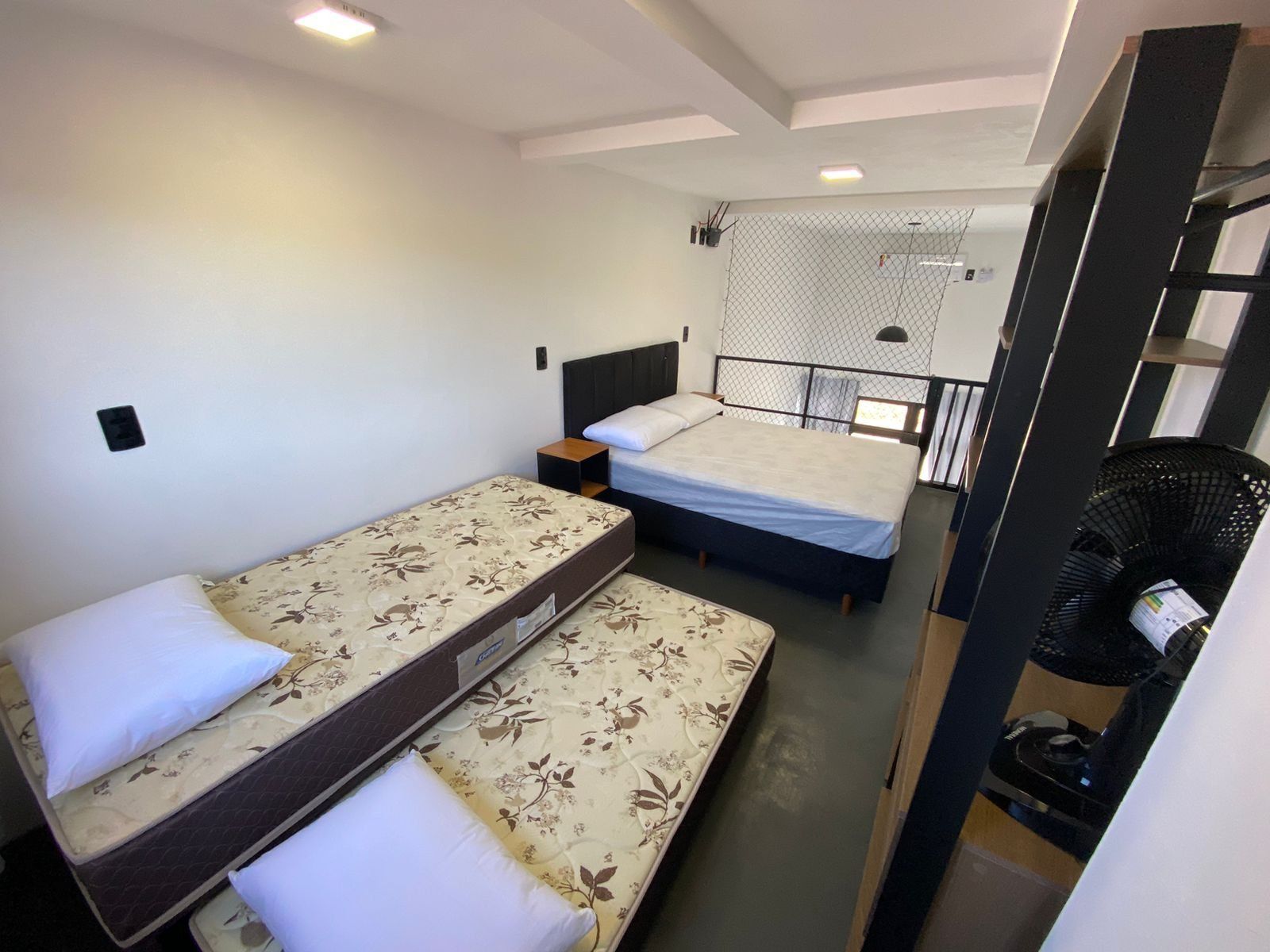 Ein kleines Zimmer mit zwei Betten, einem Tisch und einem Stuhl.