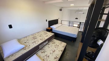 Ein kleines Zimmer mit zwei Betten, einem Tisch und einem Stuhl.