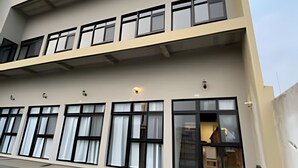 A multi-story building with large windows and a flat facade. - Lofts Meia Morada (São Francisco do Sul)
