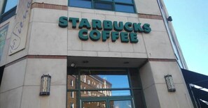 The exterior of a Starbucks Coffee building with a clear glass entrance and a visible street number 40.