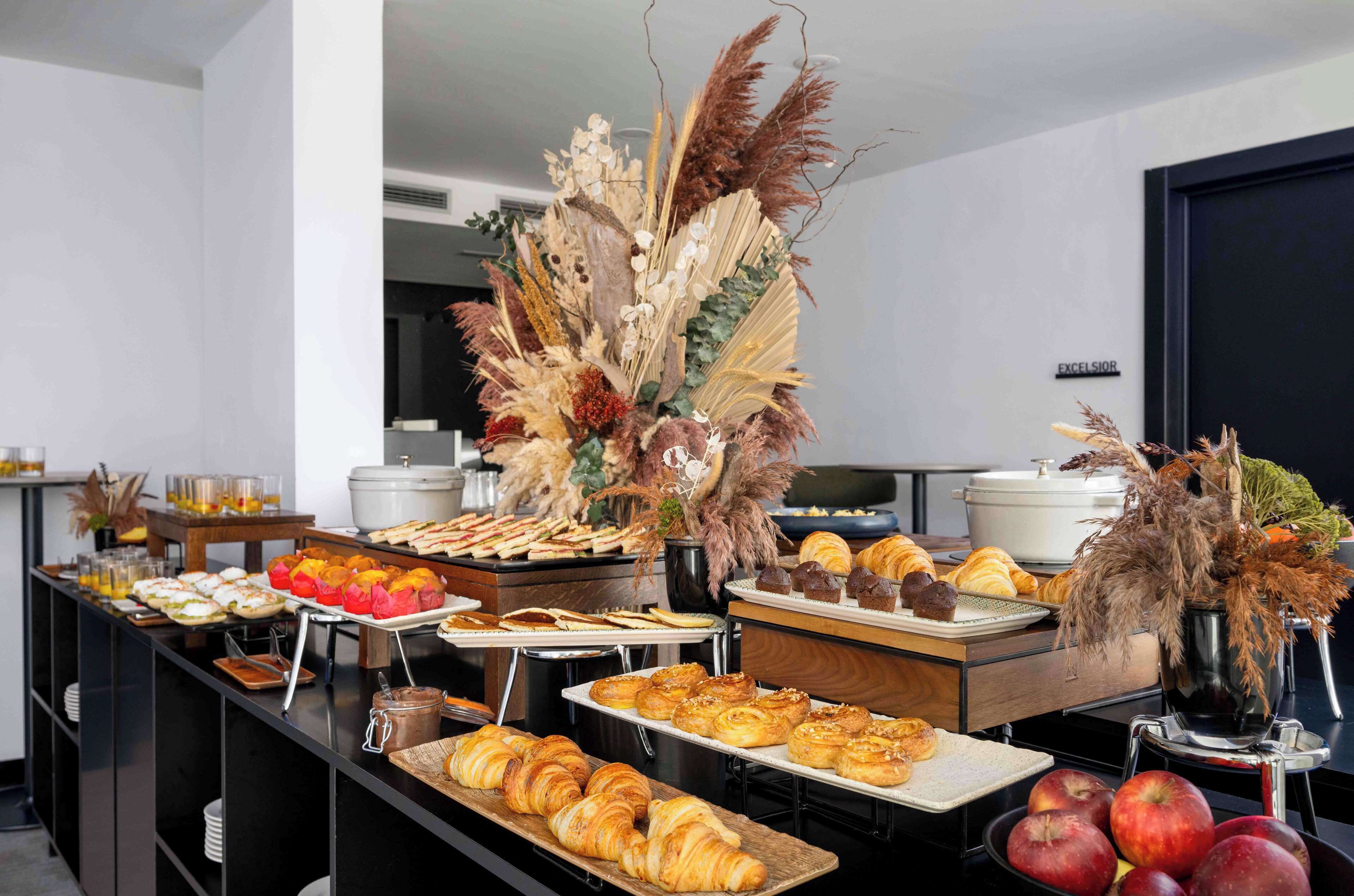 A buffet with various food items and a decorative centerpiece.