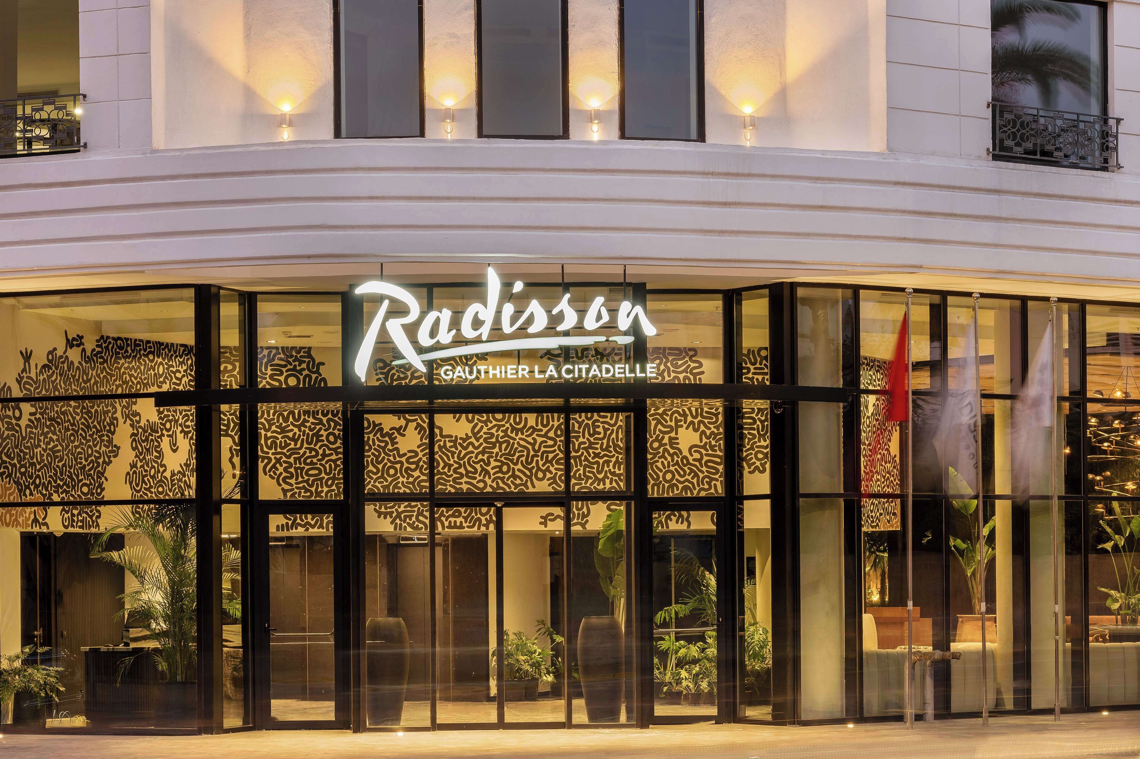 A hotel entrance with a sign reading "Radisson" and "GAUTHIER LA CITADELLE".