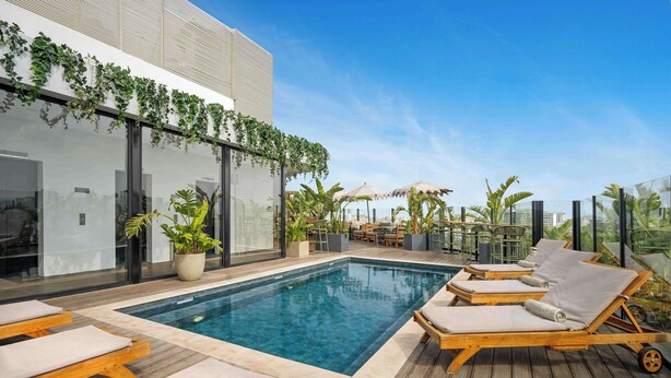 A rooftop pool area with lounge chairs, a pool, and potted plants. - Radisson Hotel Casablanca Gauthier La Citadelle (Casablanca)