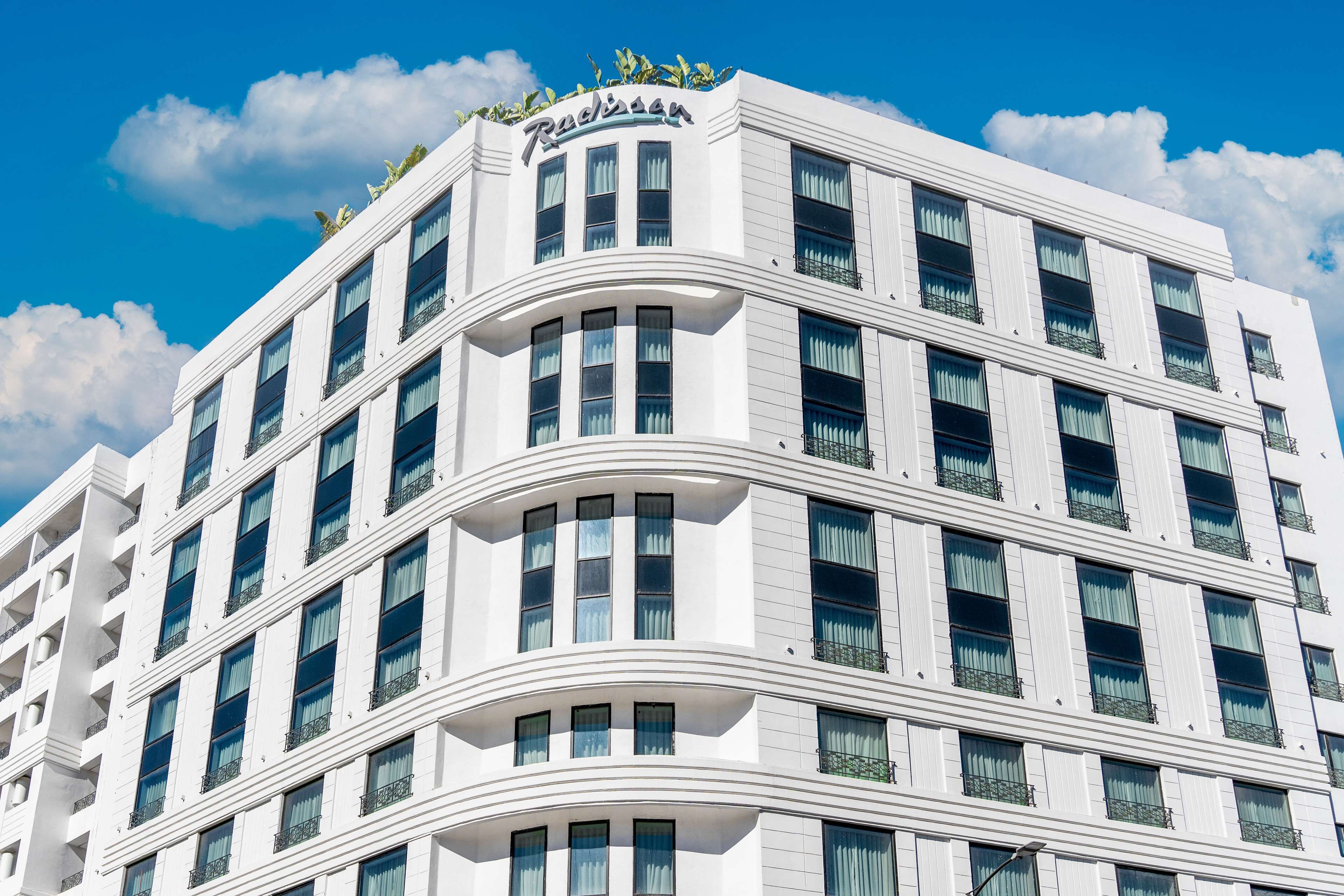 Un hotel de varios pisos con fachada curva, ventanas amplias y balcones.