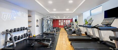 A gym with treadmills, weight machines, and dumbbells.