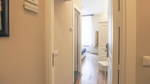 A hallway with a bed, a small table, and a chair in a bedroom. - Binaro 0 a Termini (Rome)