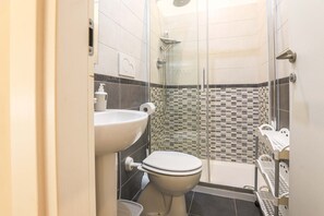 A bathroom with a toilet, sink, and shower area. - Binaro 0 a Termini (Rome)