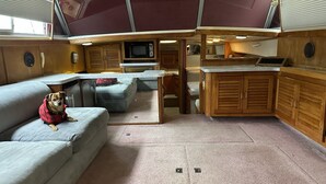 Un intérieur de camping-car compact comprenant un coin cuisine, un espace salon et un petit téléviseur.