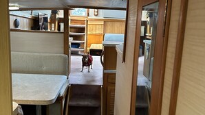 Un couloir étroit dans un camping-car, avec un chien qui se tient au bout.
