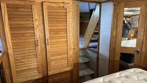 Une chambre à coucher avec un lit, une armoire en bois et une porte dotée d’un miroir.