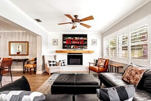 Een smart-tv, een open haard, boeken en een stereo