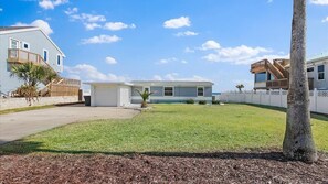 Een woonhuis met een huis van twee verdiepingen, een garage en een verzorgd gazon.