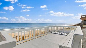 A beachside balcony with a view of the ocean and beach.