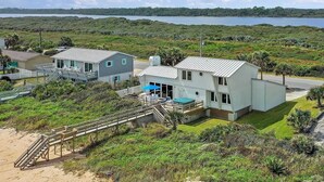A coastal property with a main house, a secondary building, and a staircase leading to a beach. - Sandy Toes Home with Hot Tub & Dune Deck (Ponte Vedra Beach)
