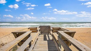 A wooden boardwalk leading to a beach with a clear sky. - Sandy Toes Home with Hot Tub & Dune Deck (Ponte Vedra Beach)