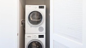 A laundry room with two stacked washing machines. - Mins to Lake Anne Plaza | In/Outdoor Yogs | Reston Town Center (Reston)