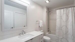 A modern bathroom with a large mirror, a sink, a toilet, and a shower area. - Mins to Lake Anne Plaza | In/Outdoor Yogs | Reston Town Center (Reston)