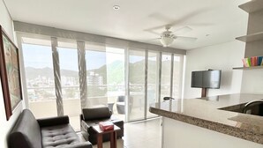Ein modernes Wohnzimmer mit einer Couch, einem Couchtisch und einem Fernseher.