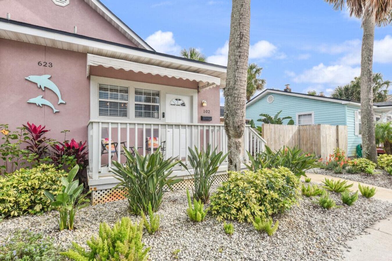A house with a porch, number 623, and a small garden with various plants.