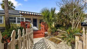 A house with a porch, a small garden, and a wooden fence.