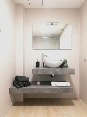 Bathroom features a large vessel sink, single faucet, and a rectangular mirror.