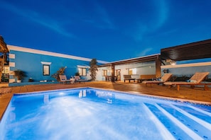 A poolside area with lounge chairs and a pool.