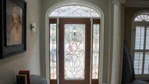 A foyer with a glass door and a framed picture on the wall.