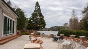 A patio with outdoor furniture and a view of a lake.