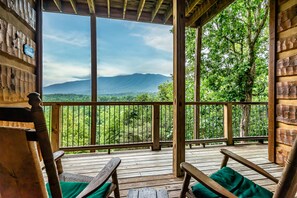 Une terrasse en bois offrant une vue sur une chaîne de montagnes.