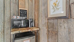 Een koffiehoek met een koffiezetapparaat, een magnetron en een bordje met de tekst 'RISE & SHINE IT'S coffee'.