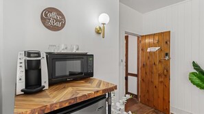 Eine Küchenzeile mit Kaffeemaschine, Mikrowelle und einer Holzarbeitsplatte.
