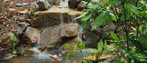 A small waterfall in a natural setting with rocks and vegetation.