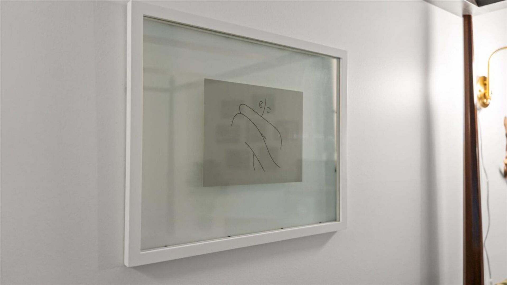 A framed artwork on a white wall.