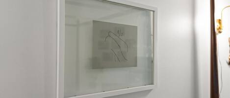 A framed artwork on a white wall.