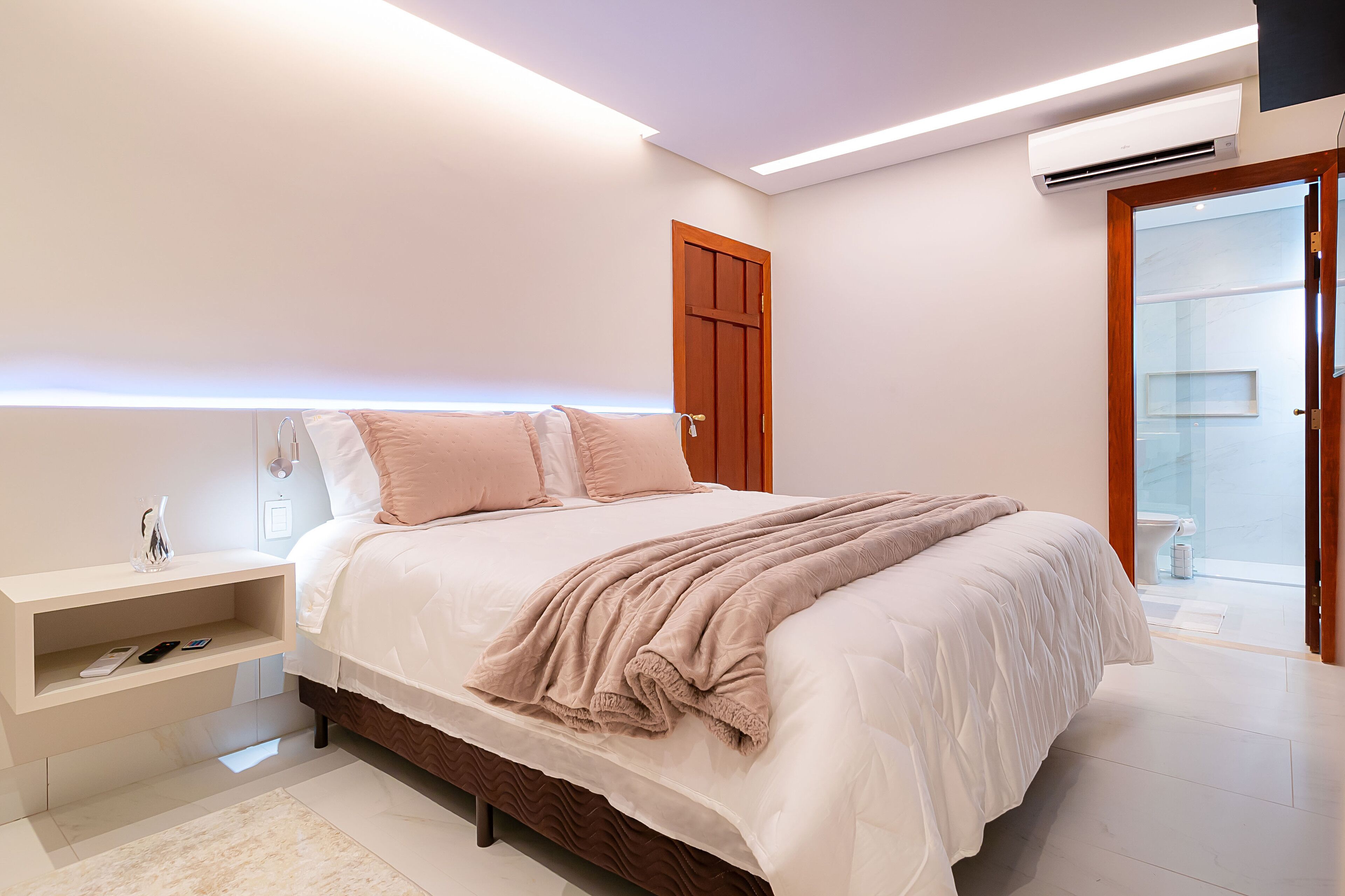 Una camera da letto moderna con un letto grande, comodini e una panca integrata.