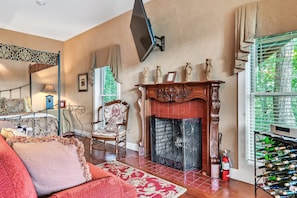 A living room with a fireplace, a television mounted on the wall, a sofa, and a wine rack.