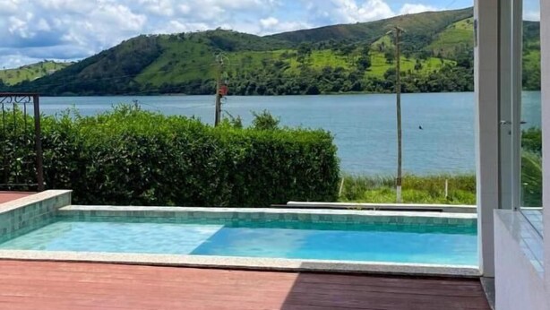 Un espace piscine avec vue sur un lac et des collines.