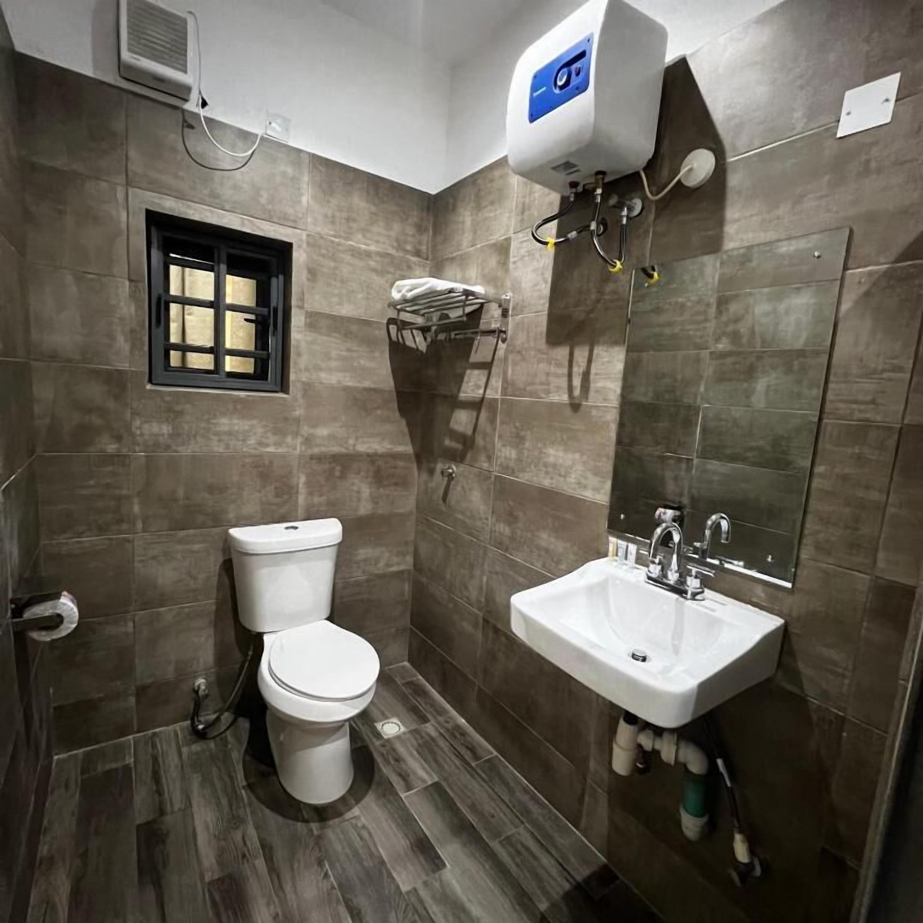 Un baño moderno con inodoro, lavabo y toallero.