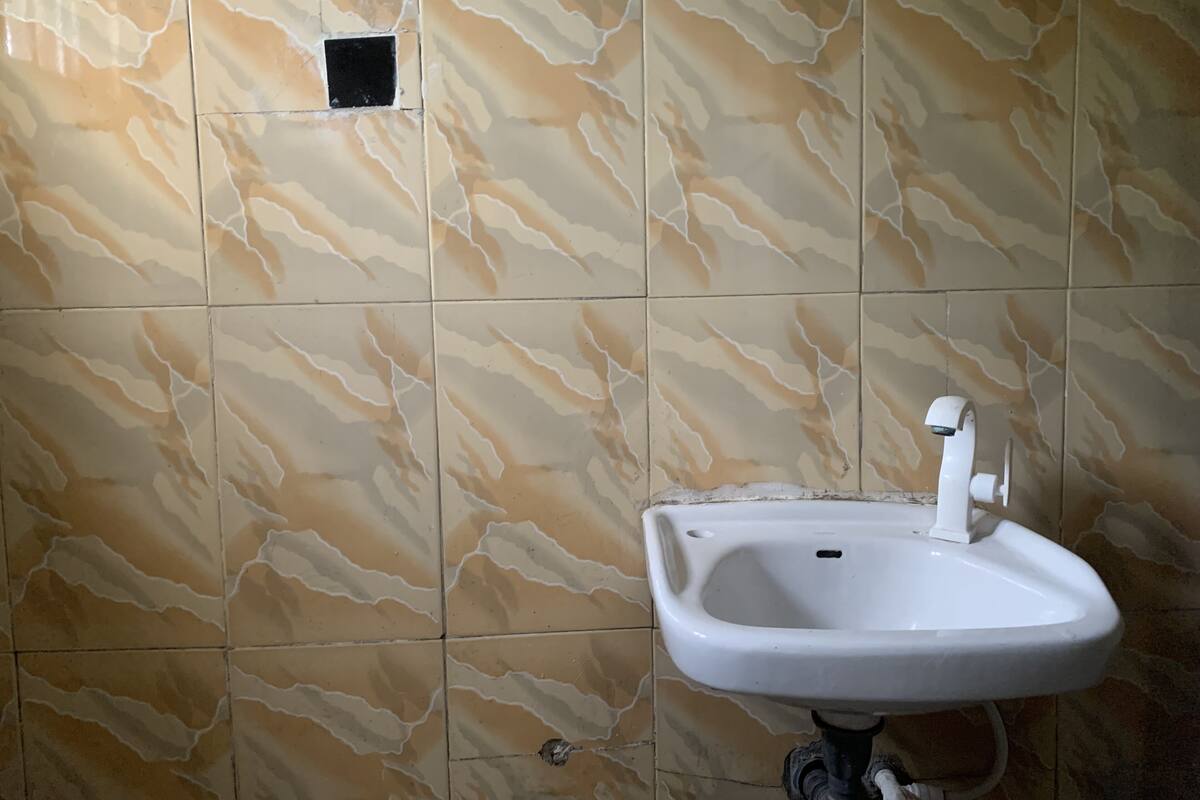 A bathroom with a sink and a wall-mounted mirror.